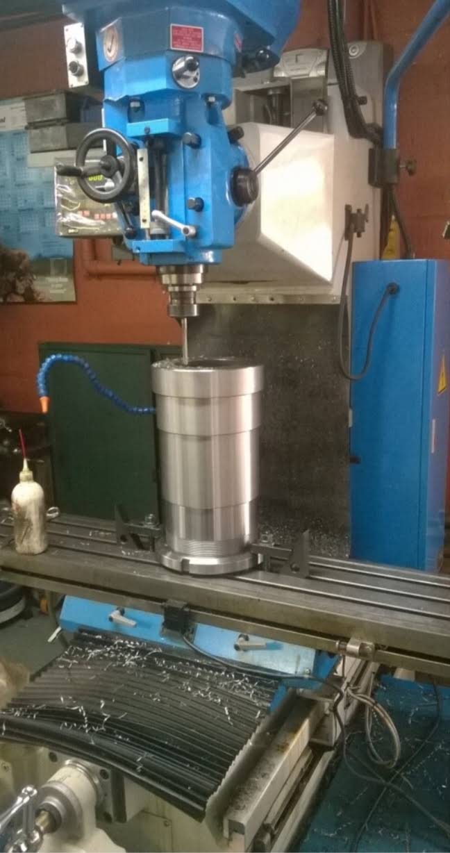 Cylindrical steel component set up under a milling head in the Camspec workshop