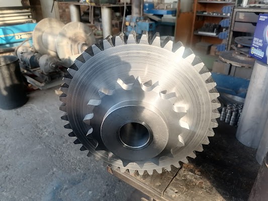 Large machined gear with cut teeth resting in the workshop